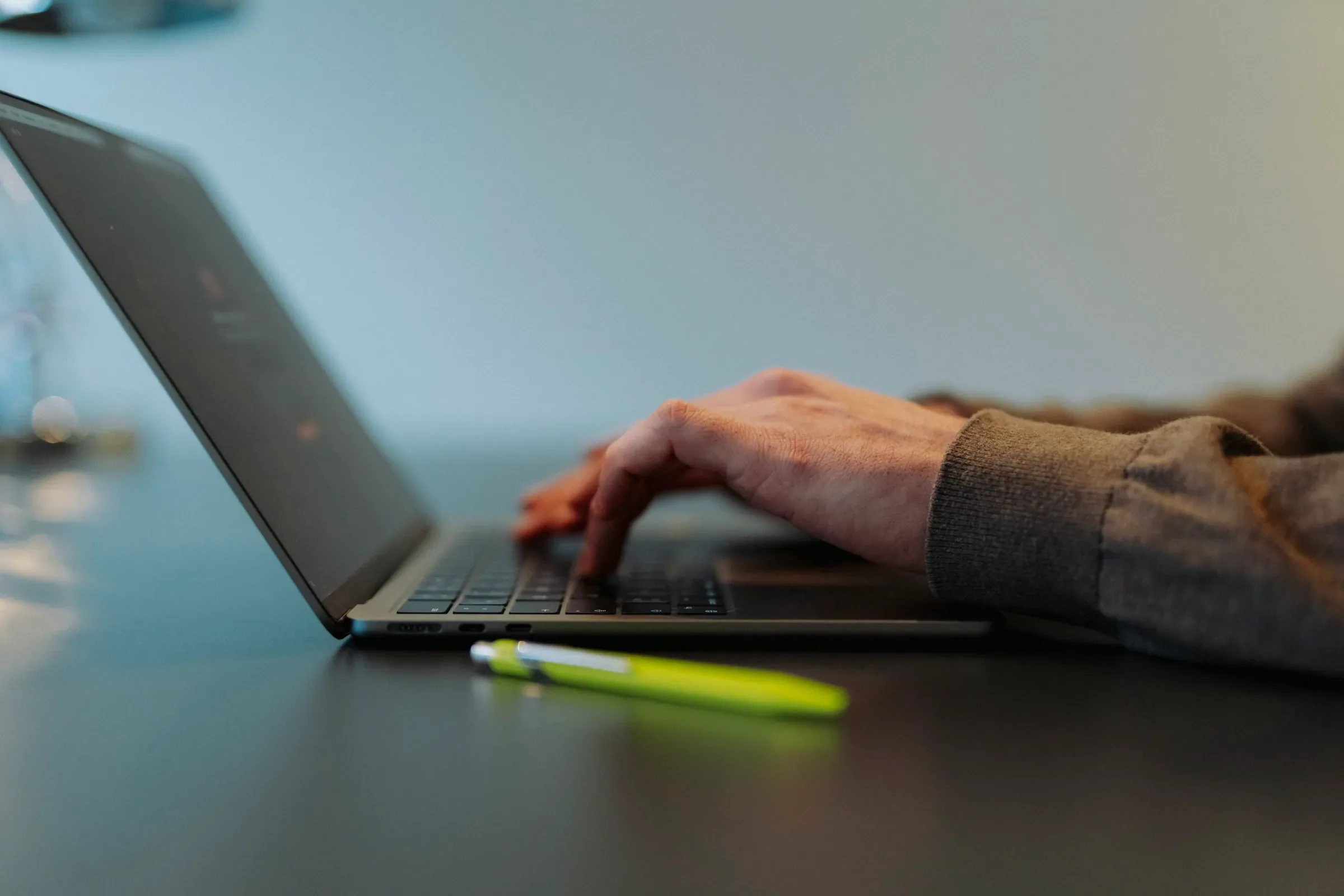 Am Laptop, Stift in Signalgelb