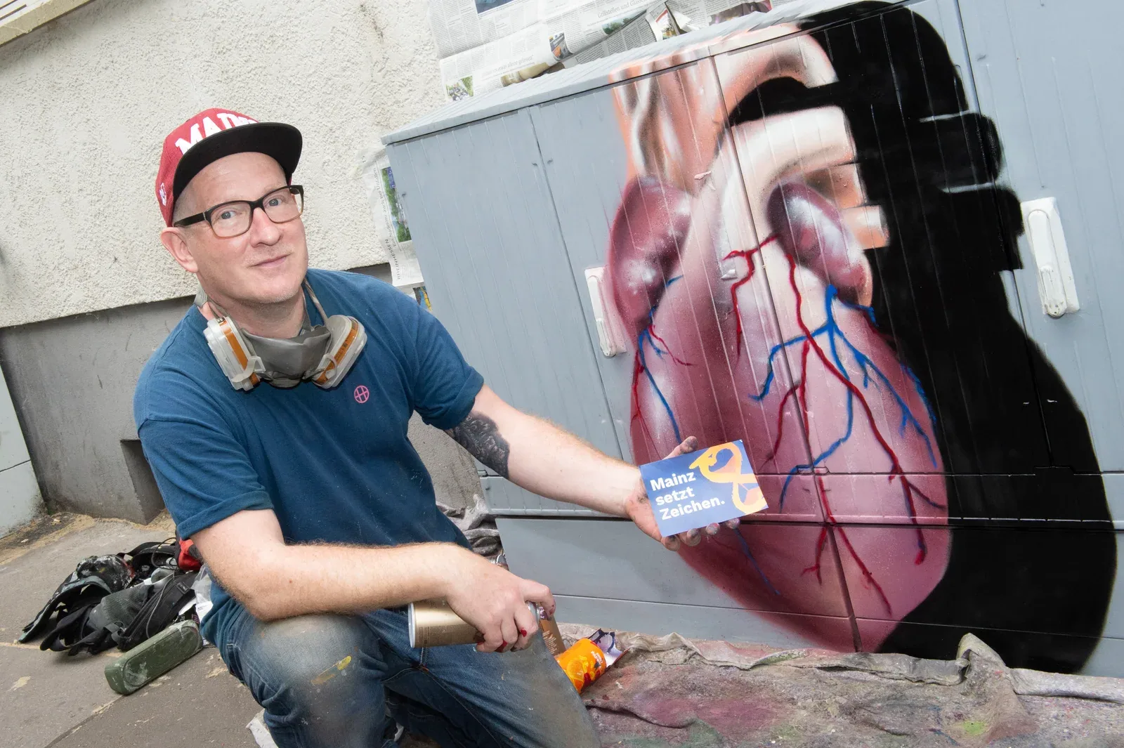 Ein Wandbild mit dem Herzmotiv entsteht waehrend des Aktionstags.